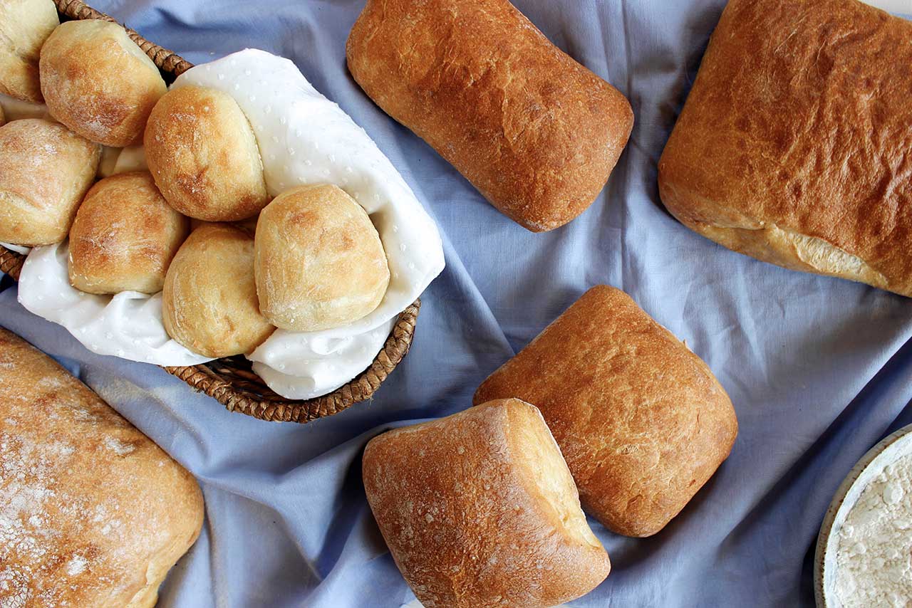 Fresh bread and rolls on a blue tablecloth