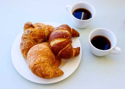 Croissants on a plate with black coffee